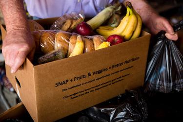 Volunteers from neighboring small towns divide, package and load their trucks with food from the Amarillo-based High Plains Food Bank for monthly delivery to Quitaque.