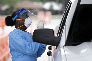 Harris County Health Department nurse Harriet Lewis administers a test at a Harris Co. testing site located at Stallworth Stadium in Baytown on March 21, 2020.